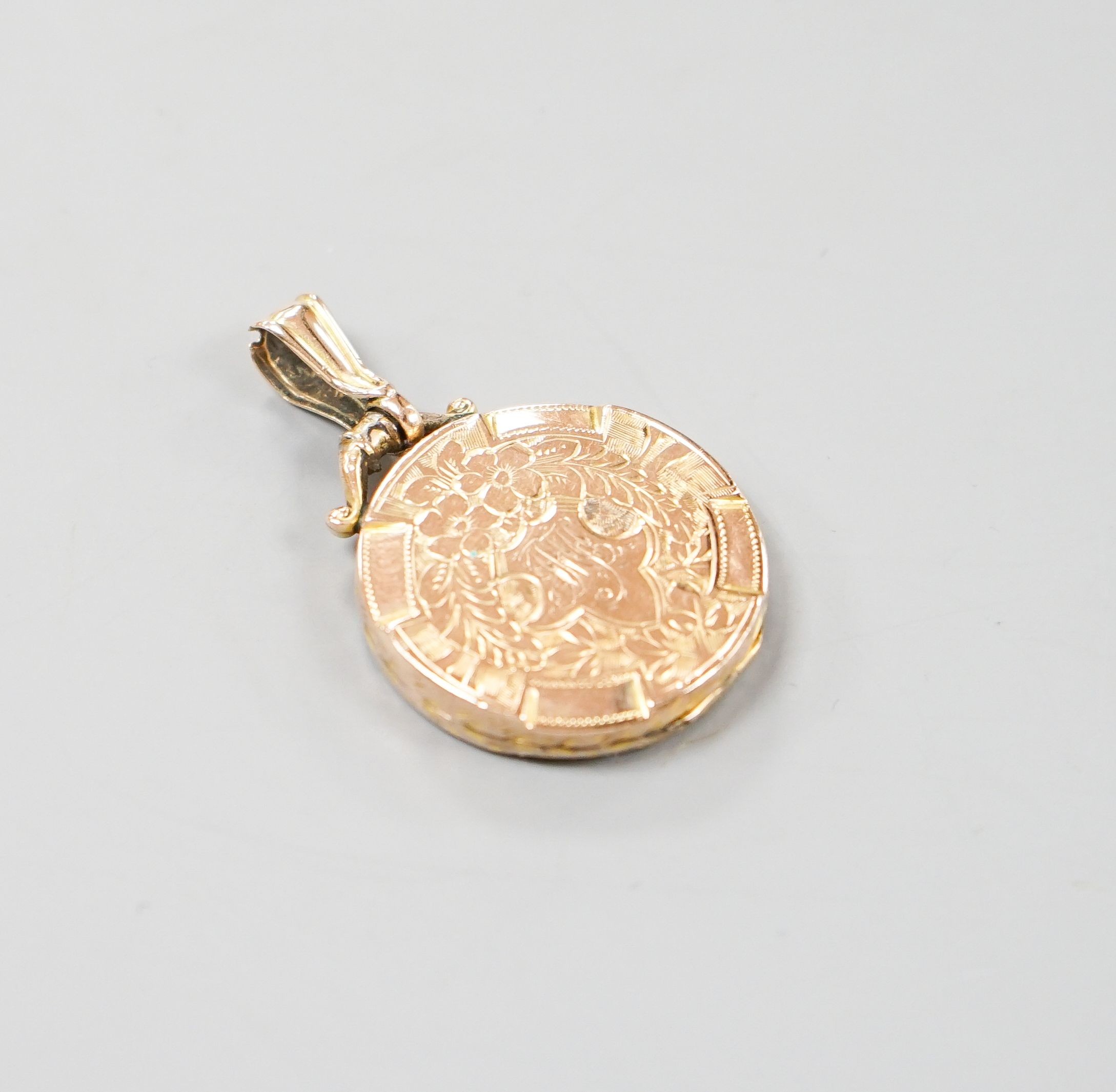 An Edwardian engraved 9ct gold circular locket, 23mm, gross weight 4.4 grams.